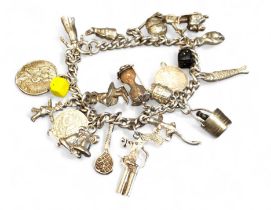 A silver charm bracelet, over twenty charms including champagne bucket, flintlock pistol, Vespa,