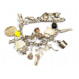 A silver charm bracelet, over twenty charms including champagne bucket, flintlock pistol, Vespa,