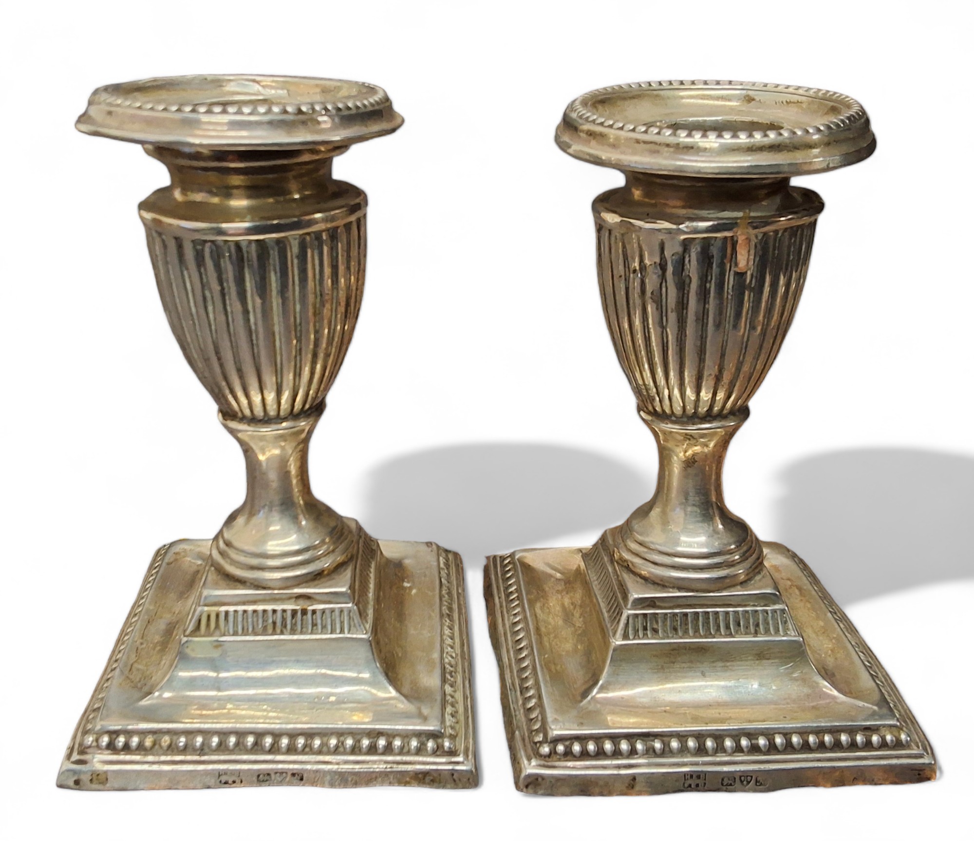 A pair of George V silver boudoir candlesticks, detachable beaded nozzles, fluted sconces, spreading