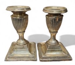 A pair of George V silver boudoir candlesticks, detachable beaded nozzles, fluted sconces, spreading