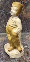 A Royal Vienna figural stick pin holder, of a Dutch boy, in traditional dress, picked out in