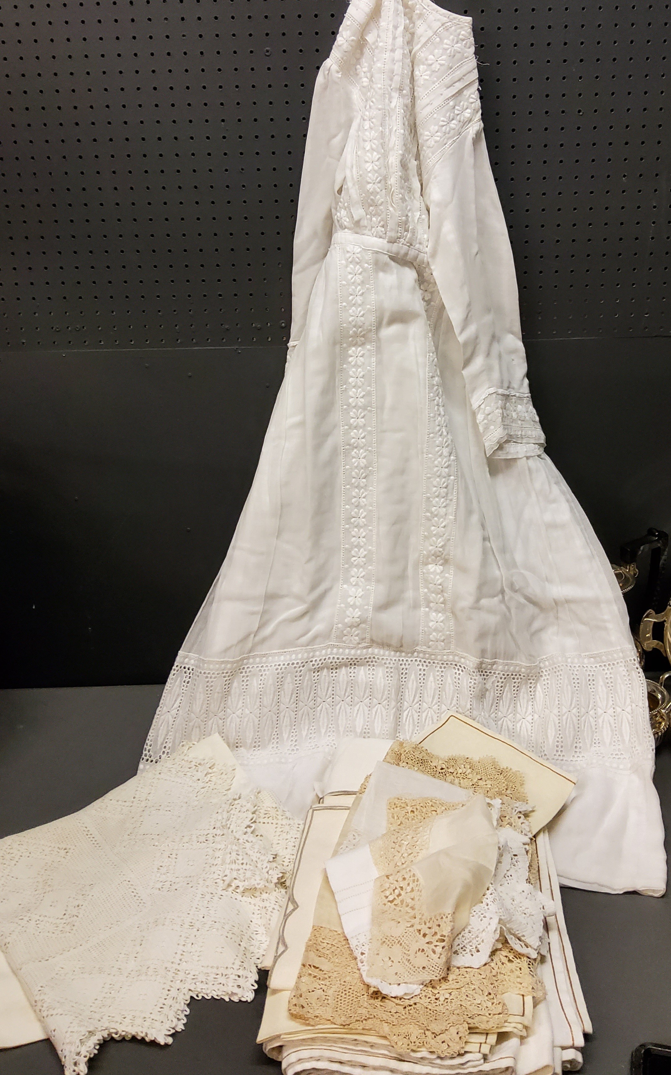 Textiles - an early 20th century cotton dress, c.1910;  lace table cloth and doylees;  etc