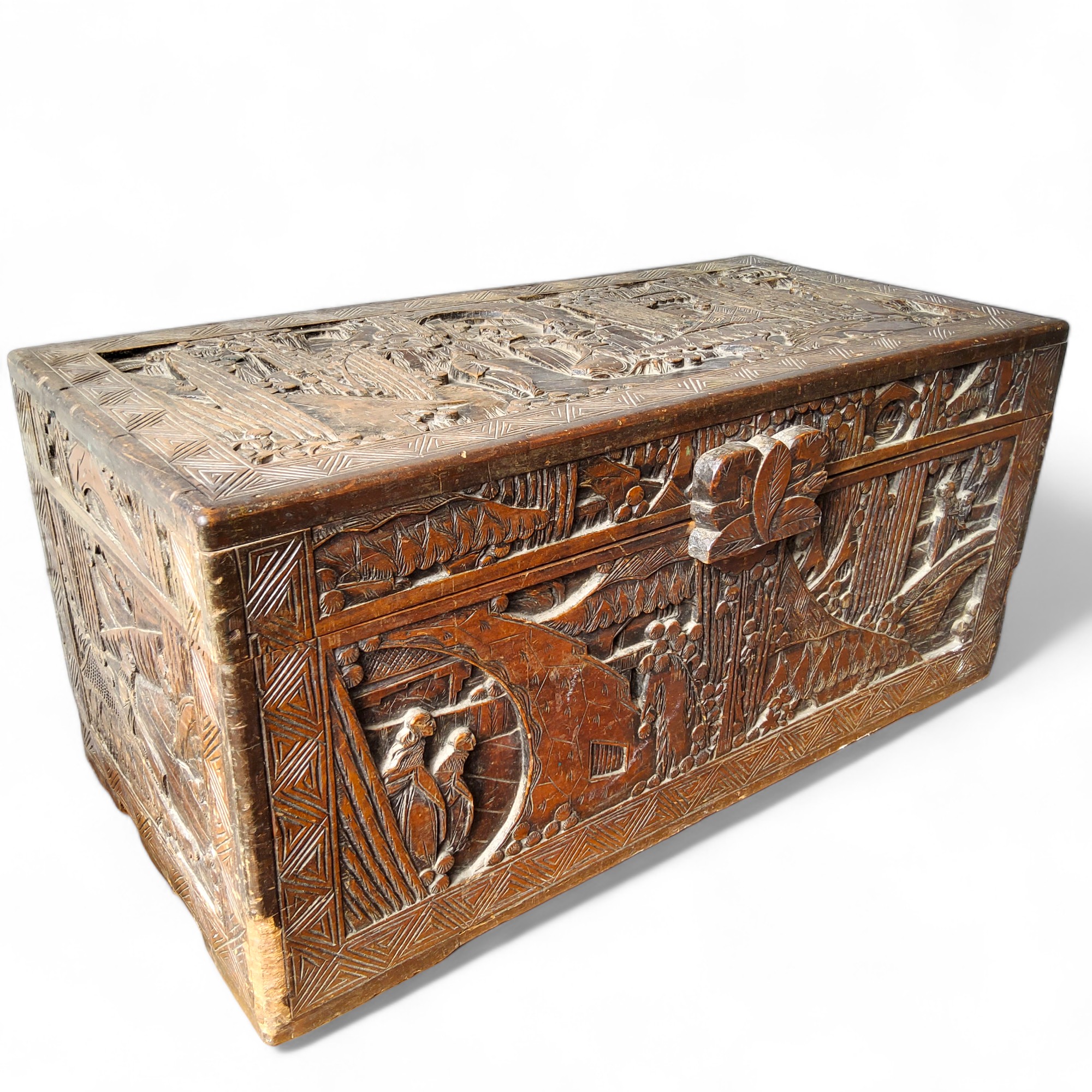 A Chinese camphor wood blanket box, carved in relief with traditional scenes, 101cm wide, 47cm high,