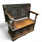 An early 20th century oak carved monks bench, 104cm wide