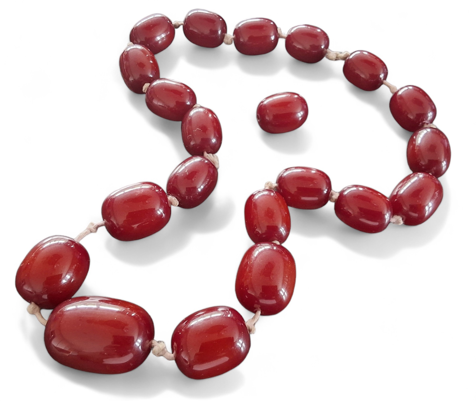 A cherry amber bead necklace + one spare bead, gross weight approx 214g gross, largest bead measures