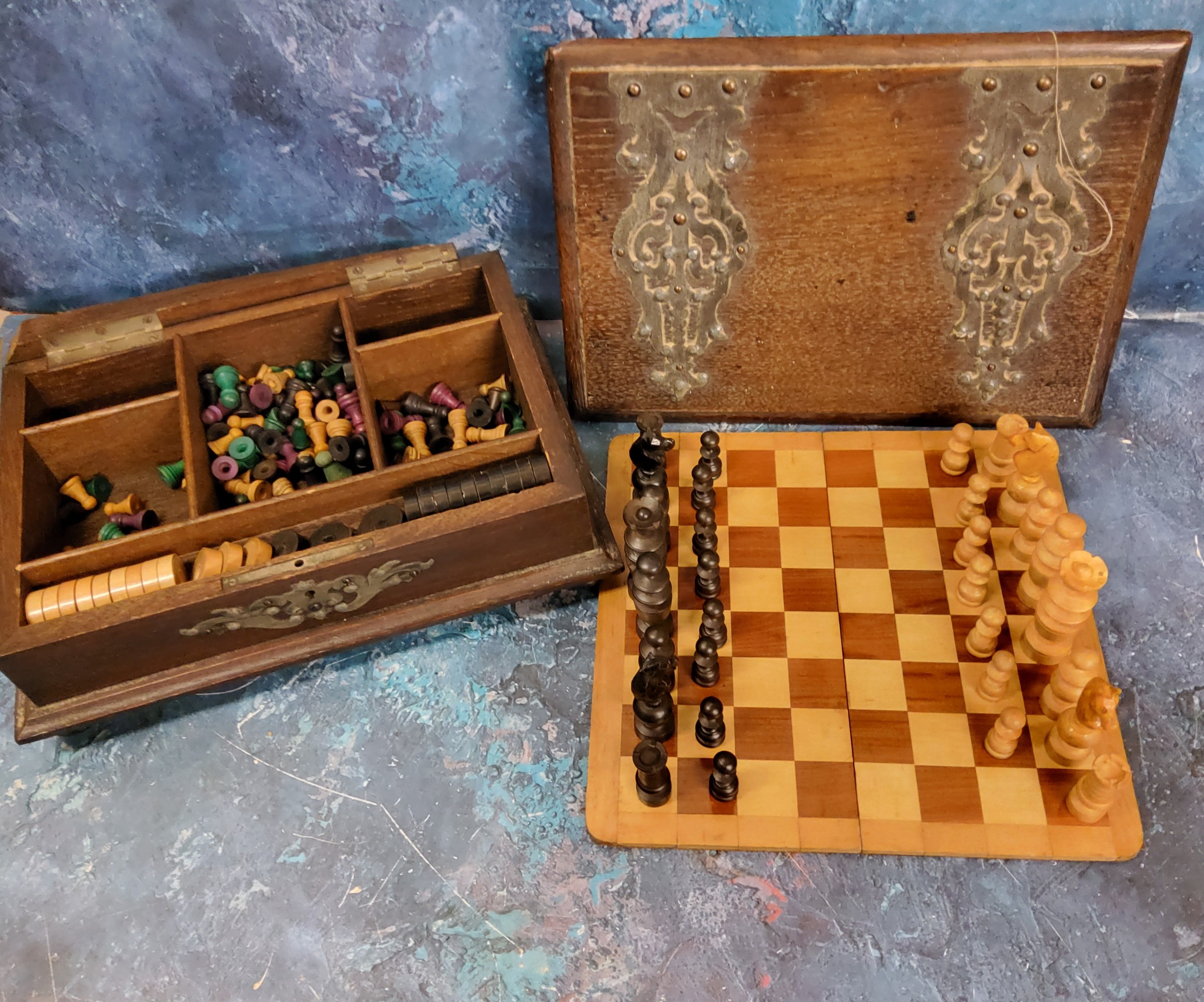 A late 19th century games compendium, turned wooden chess pieces, draughts, etc, the oak box with
