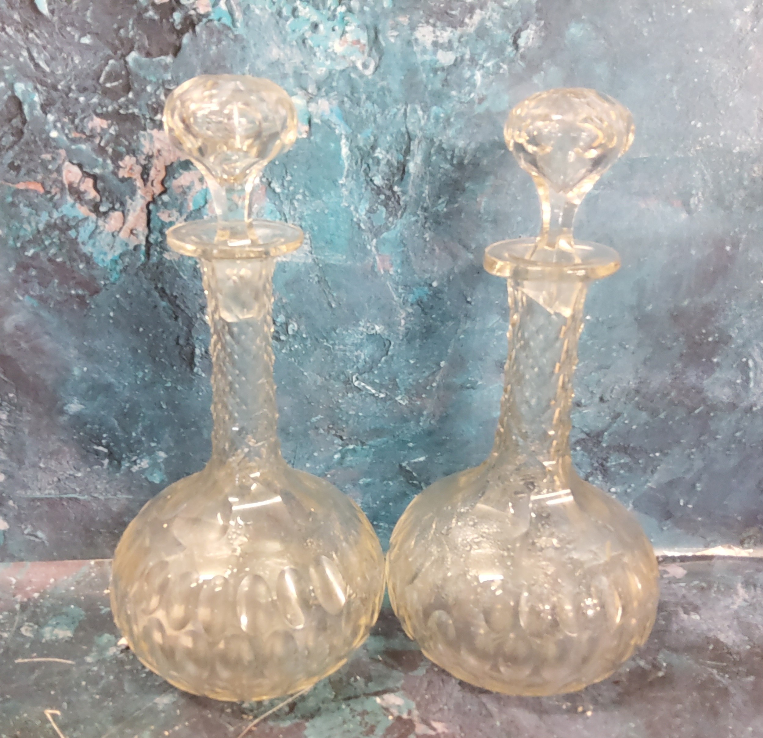 A pair of clear glass bottle decanters and stoppers, cut with ovals, facet cut necks, 25cm high