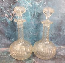 A pair of clear glass bottle decanters and stoppers, cut with ovals, facet cut necks, 25cm high