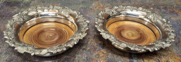 A pair of Regency Old Sheffield plate wine coasters, the rims applied with fruiting vine, draught