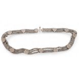 An Indian white three row metal curb link belt, surmounted by alternating hearts & clover leaves,