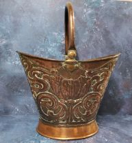 An Art Nouveau copper helmet shaped coal bucket, embossed with stylised tulip and scrolls, swing