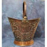 An Art Nouveau copper helmet shaped coal bucket, embossed with stylised tulip and scrolls, swing