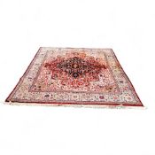 A large Persian Tabriz carpet, machine produced woolen pile, central flowerhead boss bordered with