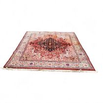 A large Persian Tabriz carpet, machine produced woolen pile, central flowerhead boss bordered with