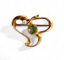 A 15ct gold Art Nouveau scroll brooch, set with an oval peridot and seed pearl, 3.4g