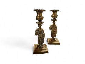 A pair of Regency bronzed figural candlesticks, detachable floral nozzles, spreading square bases,