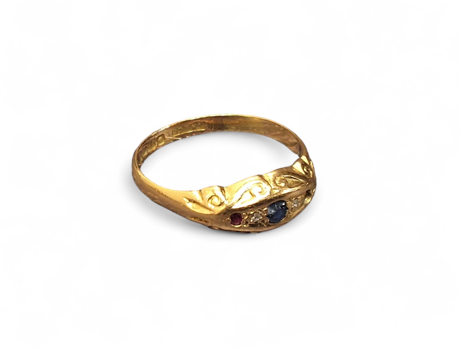 A Victorian 18ct gold Gypsy three stone ring set with a central round sapphire flanked by two rubies