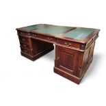 An early 20th century mahogany twin pedestal partners desk, three panel leather writing surface with