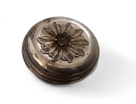 A silver circular trinket box, the cover with filigree flower, 5.5cm diam, London 1986