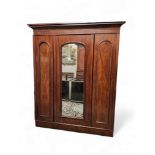 A Victorian mahogany compactum wardrobe, outswept cornice, two arched panel doors and central