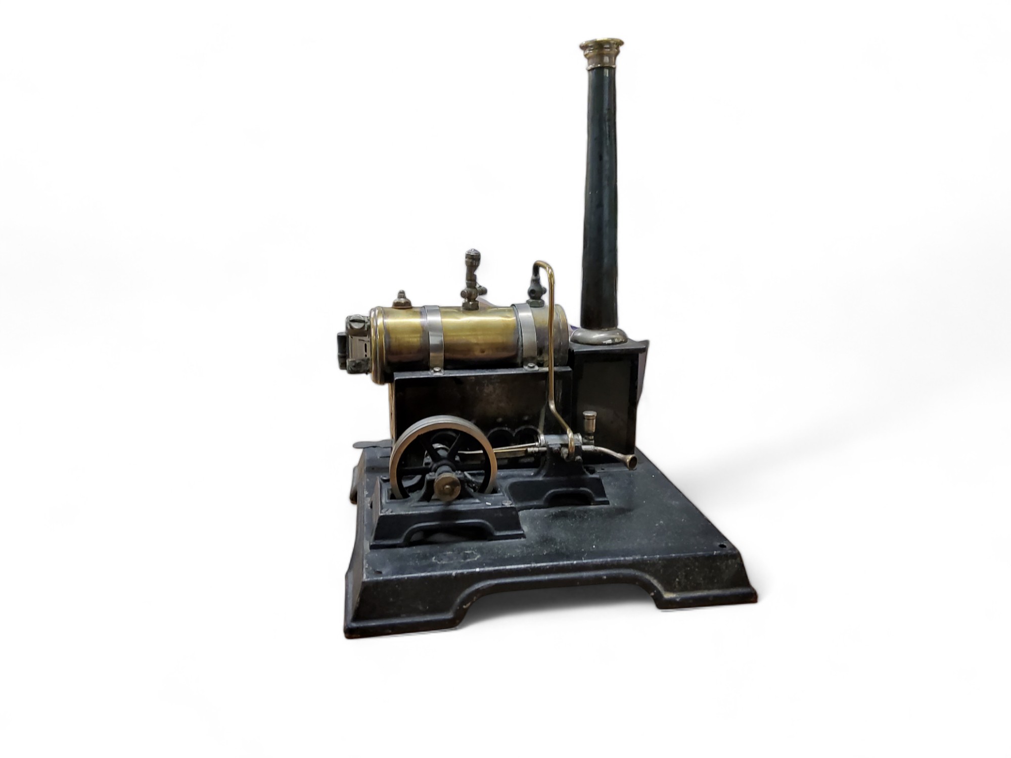 A Marklin brass and tin plate steam engine, with a single fly wheel, pressure gauge and chimney,