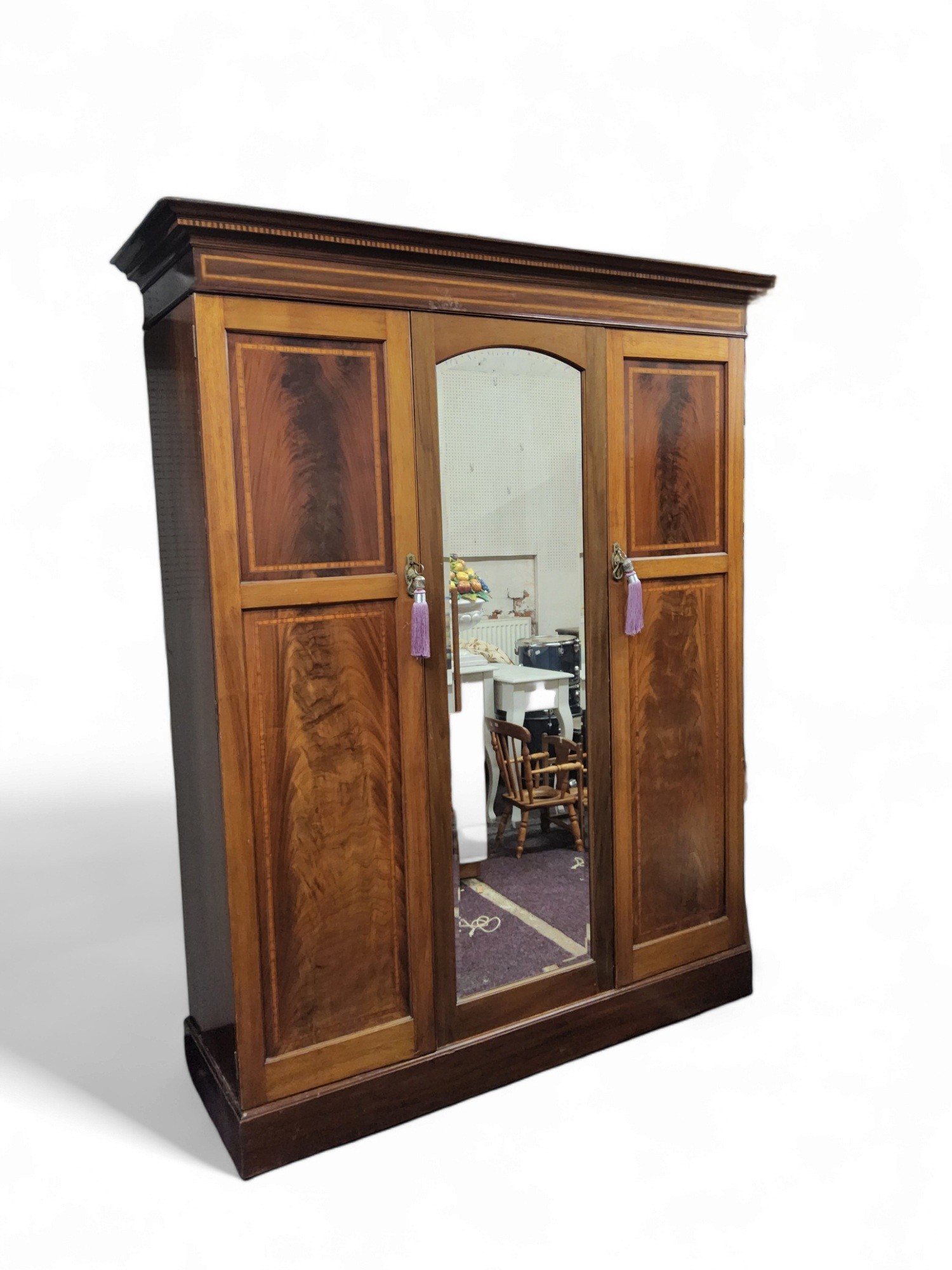 An Edwardian mahogany double wardrobe, upswept cornice, panelled doors with boxwood stringing,