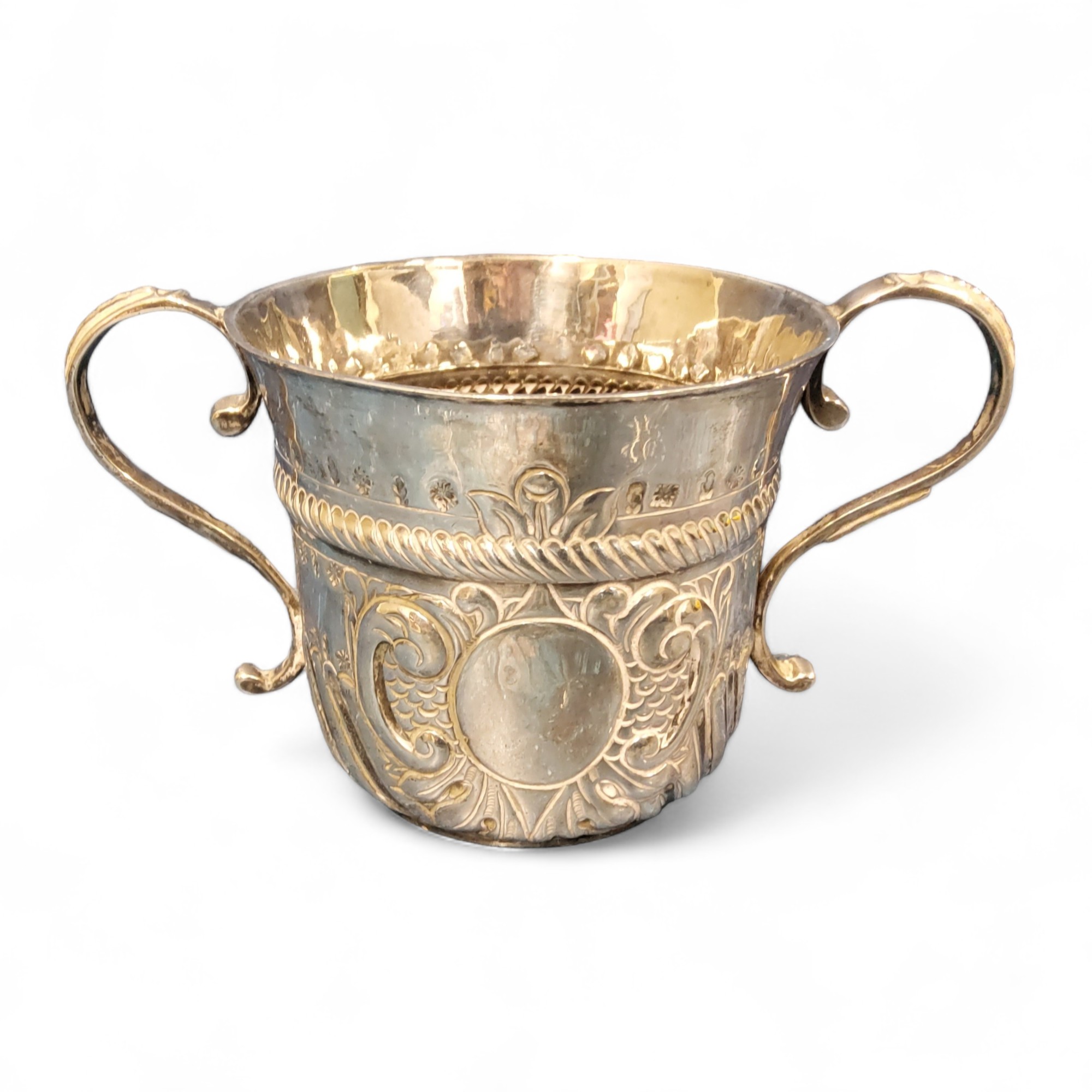 A Queen Anne Britannia standard silver porringer, with fluted and punched vacant cartouche, embossed