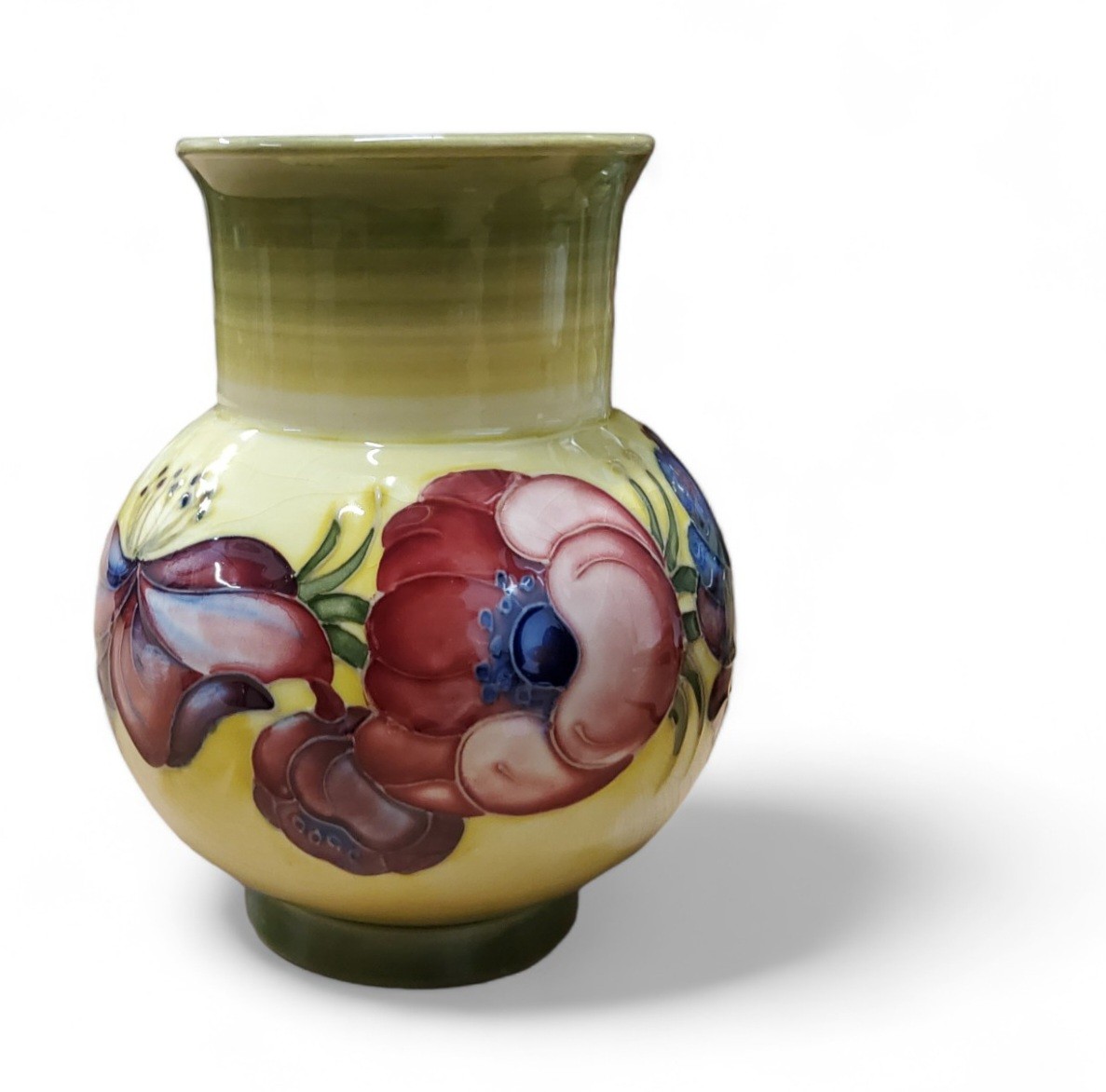 A Moorcroft  Anemone vase, tube lined with large flowerheads on a on mottled yellow and green