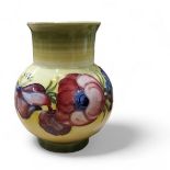 A Moorcroft  Anemone vase, tube lined with large flowerheads on a on mottled yellow and green