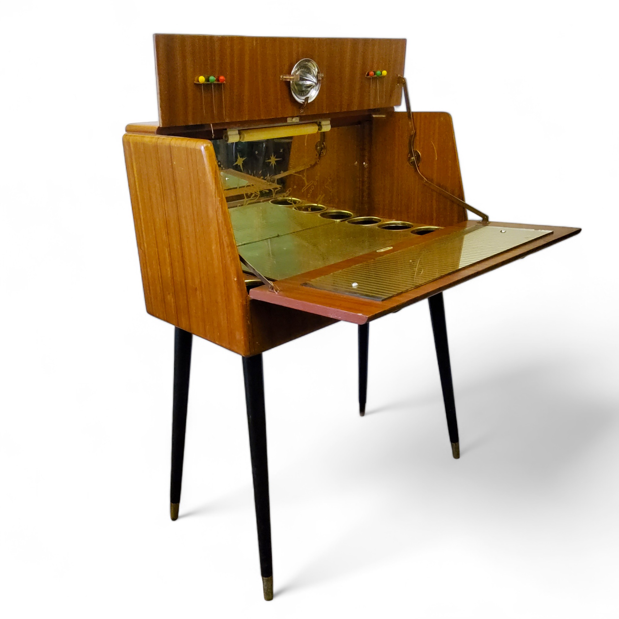 A mid 20th century cocktail cabinet by Rivington, the fall front revealing ilustrated mirror back