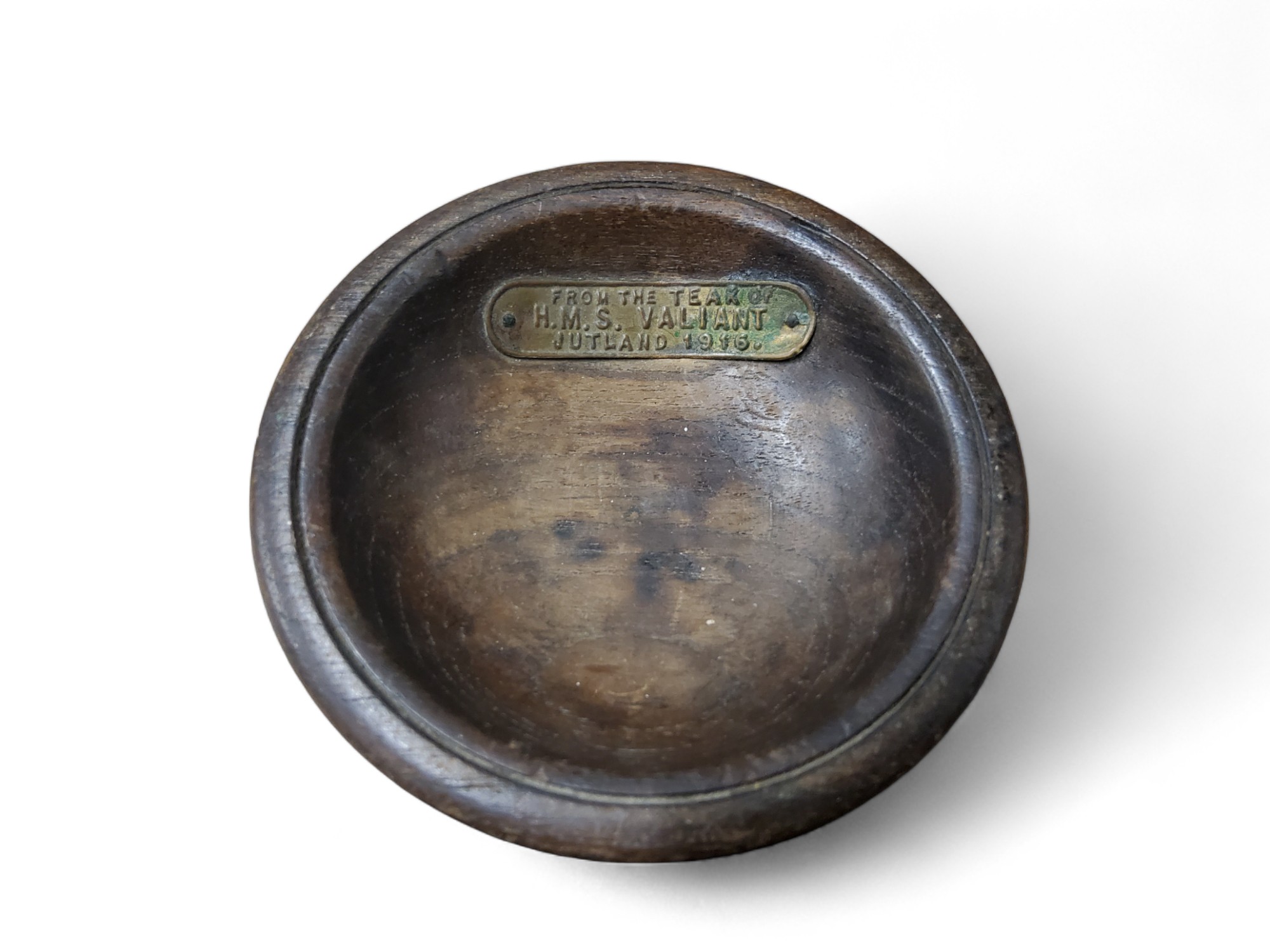 An early 20th century circular pin dish, with plaque, From the teak of H.M.S. Valiant, Jutland 1916,