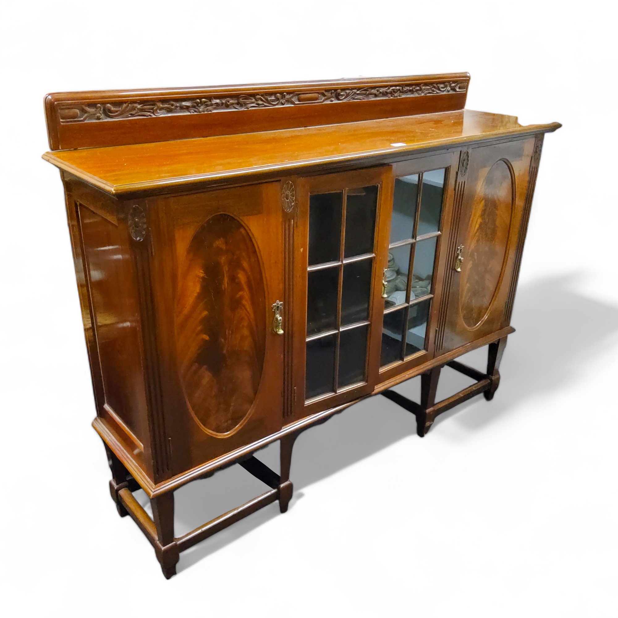 A Victorian mahogany display cabinet, glazed doors flanked by oval panel doors, tapered legs,