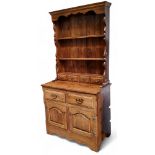 A 20th century oak side cabinet, shaped apron above two shelves and four spice drawers, the
