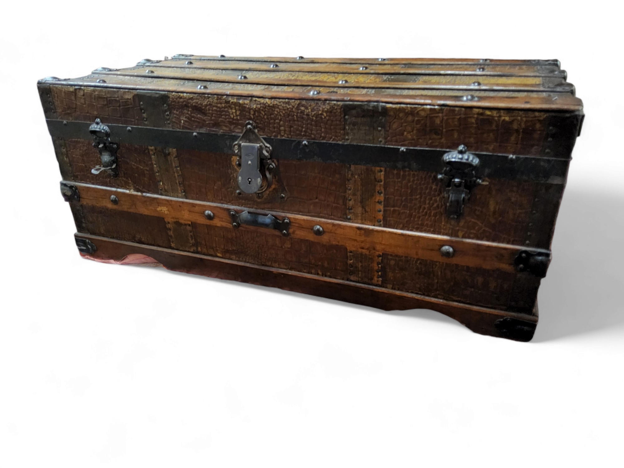 An early 20th century wood and pressed metal faux crocodile skin bound travel trunk