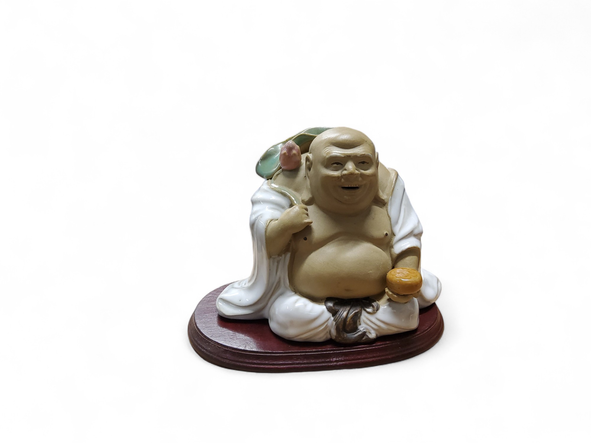 A Chinese pottery figure, of a Budai, holding a lotus, 13cm high, hardwood base