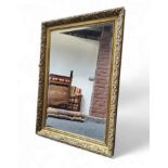 A 20th century rectangular bevelled edge wall mirror, foliate gilt frame, 89cm high, 62cm wide.