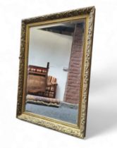 A 20th century rectangular bevelled edge wall mirror, foliate gilt frame, 89cm high, 62cm wide.
