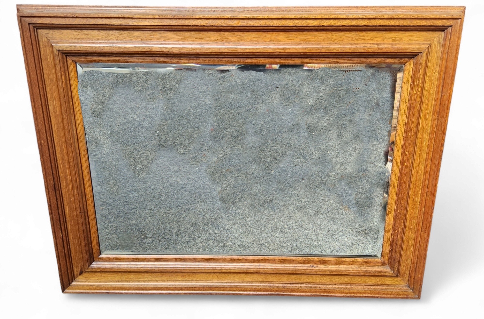 An early 20th century golden oak rectangular bevelled  mirror, stepped frame, fielded panel frame,