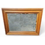 An early 20th century golden oak rectangular bevelled  mirror, stepped frame, fielded panel frame,