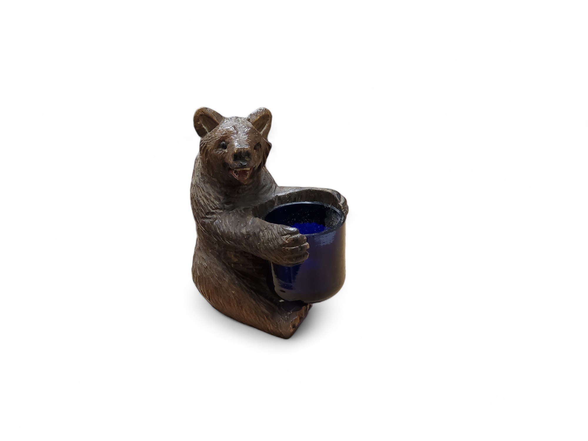 A novelty  Black Forest bear table vesta, seated, holding a blue well, 9cm high