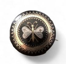 A Victorian circular tortoiseshell pique ware brooch decorated with a butterfly, 32mm dia.