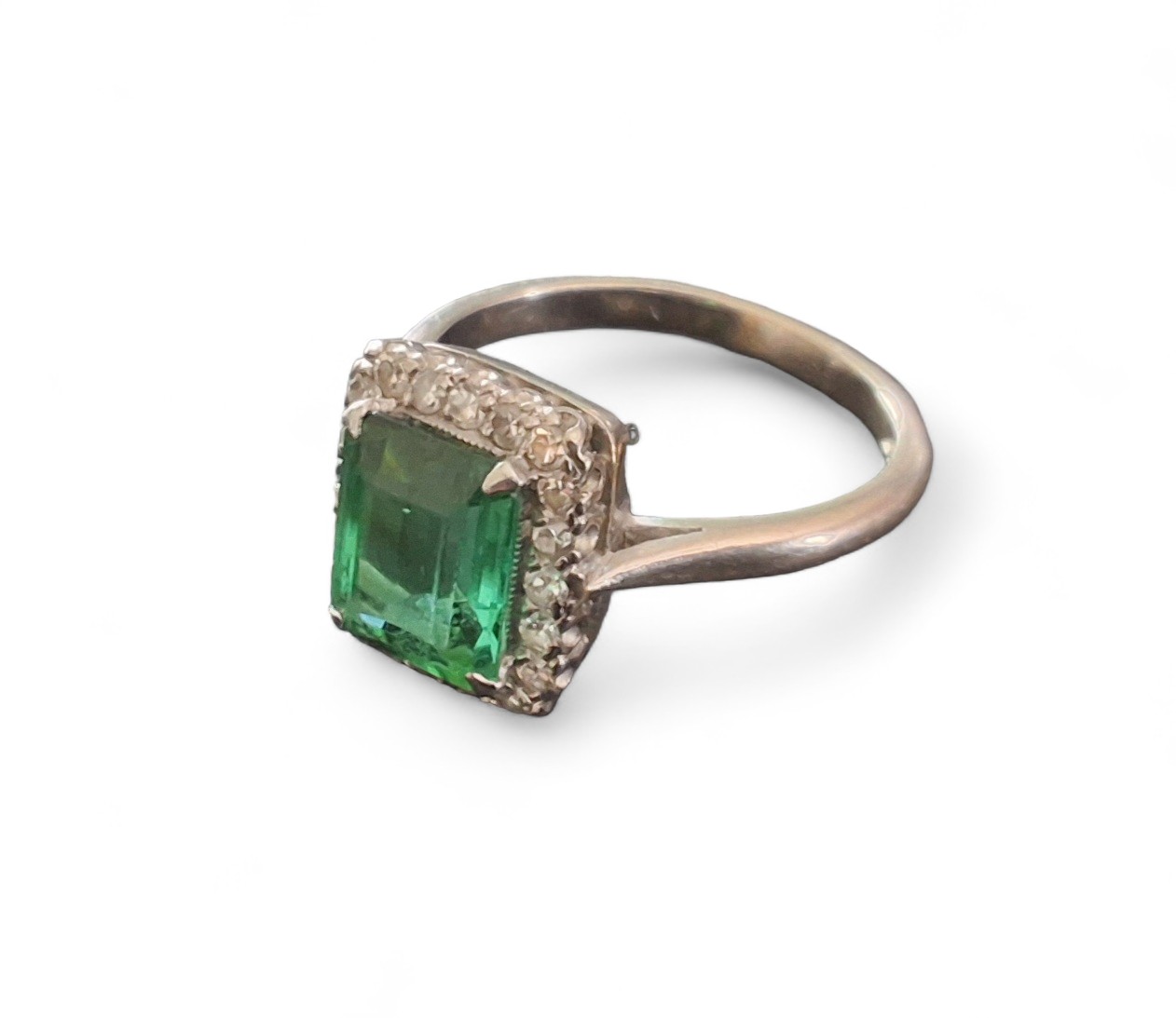 An 18ct white gold and Platinum ring, set with an emerald cut green Tourmaline, xx X xxmm within a