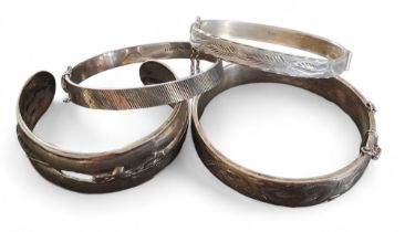 A silver hinged bangle, chased and engraved with scrolls, Excalibur Jewellery Ltd, Birmingham, 1974;