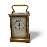 A 19th century French brass carriage clock, Arabic numerals, bevel glass panels, swing handle,