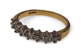 An 18ct gold and diamond half eternity ring, claw set with seven round diamonds, total approx.