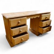 A pine pedestal kneehole desk, each pedestal holding three drawers, bracket feet, 75cm x 137cm x