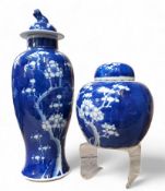 A Chinese Kangxi period baluster vase and cover, decorated in blue and white blossoming prunus; a