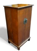 A  mahogany cabinet, in in the Oriental manner, circular lock plate, opening to reveal multiple