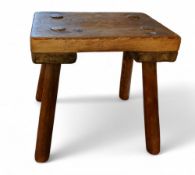 A rustic pine milking stool, rectangular top, 26cm high, 25cm wide, early 20th century