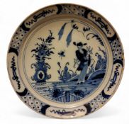 An 18th century  delft plate, possibly English, decorated in cobalt blue with an oriental figure